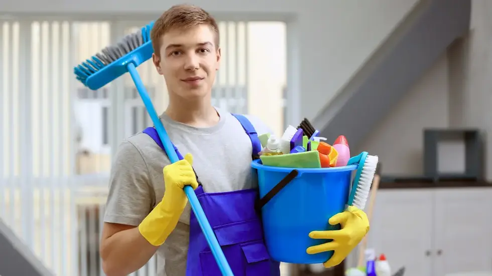 man holding bucket with cleaning materials