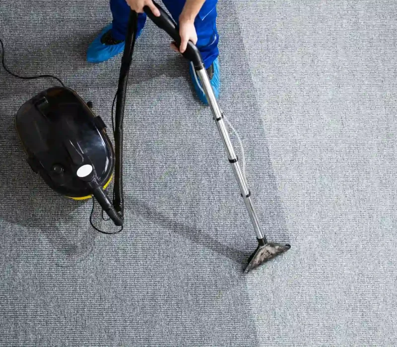 Janitor Cleaning Carpet With Vacuum Cleaner